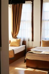 a bedroom with two beds and a window with curtains at Konak Hotel Kaleiçi in Antalya