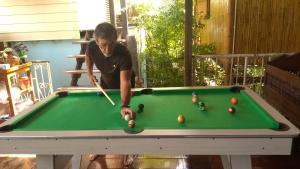 Ein Mann spielt Billard an einem Billardtisch in der Unterkunft Cast Away in Nonthaburi