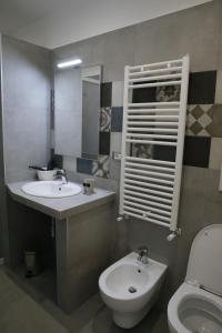 ein Badezimmer mit zwei Waschbecken, einem WC und einem Spiegel in der Unterkunft Capitelli in Neapel