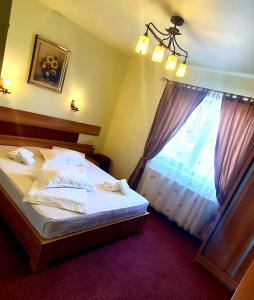 a bedroom with a large bed and a window at MOTEL COOL in Bărcăneşti