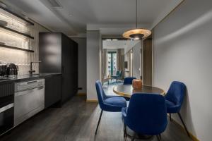 a kitchen with a table and blue chairs at Be Mate Paseo de Gracia in Barcelona