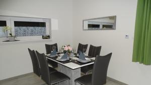 uma sala de jantar com uma mesa e cadeiras pretas em Jenny home em Mojmírovce