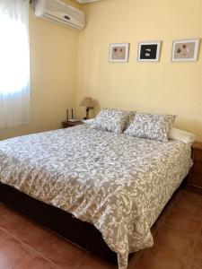 um quarto com uma cama com um edredão branco em Playa y tranquilidad en El Portil em El Portil