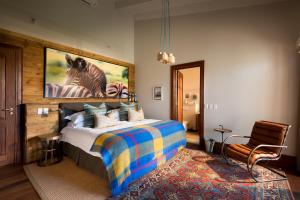 1 dormitorio con 1 cama con una foto de cebra en Kwandwe Fort House, en Grahamstown