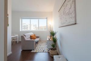 - un salon avec une chaise et une table dans l'établissement Apartment Boavista Roundabout by Sweet Porto, à Porto 37 autres photos
