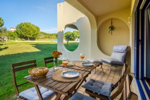 a table and chairs on a patio with a view of a yard at PARAISO DE ALVOR - A true paradise in an amazing nature place with direct access to the pool - Peace and relax - next to Alvor Village and the beach in Alvor