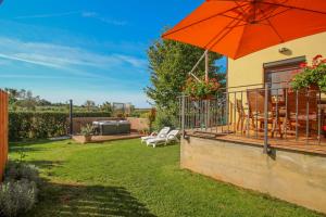 a patio with an orange umbrella and a table and chairs at Villa Agata in Dajla