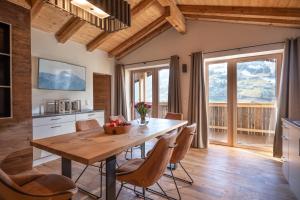 een keuken en eetkamer met een houten tafel en stoelen bij Apartments Zauberberg in Hainzenberg
