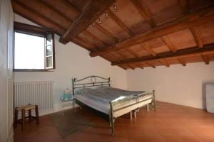 Podere Bruscoline 36 في ماسا ماريتيما: سرير في غرفة ذات سقف خشبي
