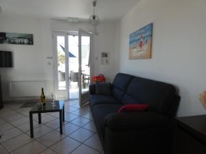 a living room with a blue couch and a table at Omaha gîtes in Vierville-sur-Mer