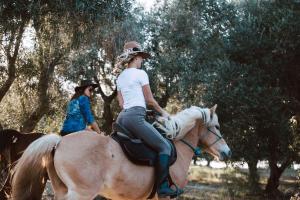 two girls riding on a horse in a field at Acaya Golf Resort & Spa in Acaya