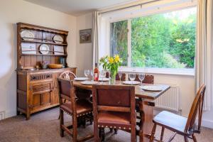 a dining room with a wooden table and a window at Beaver Cottage in Aldeburgh +24 photos