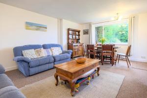 a living room with a blue couch and a table at Beaver Cottage in Aldeburgh