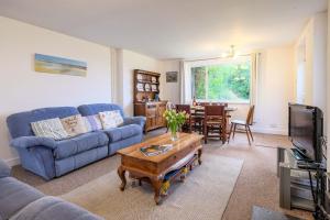 a living room with a blue couch and a table at Beaver Cottage in Aldeburgh