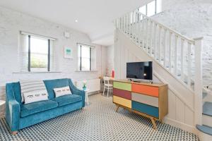 uma sala de estar com um sofá azul e uma televisão em Connells Barn Conversion em Duleek