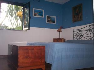 a blue bedroom with a bed and a window at Villa Marianna in Ricadi