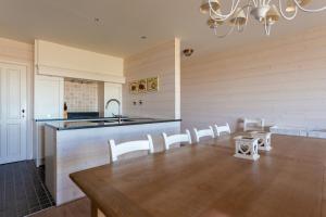 cocina grande con mesa y sillas blancas en Apartment Zonnehaven, en Nieuwpoort