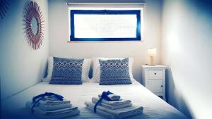 a bedroom with towels on a bed with a window at PARAISO DE ALVOR - A true paradise in an amazing nature place with direct access to the pool - Peace and relax - next to Alvor Village and the beach in Alvor +25 photos