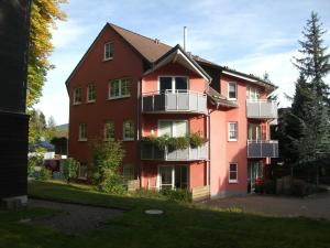 a large red building with white balconies on it at Fewo Schröder - Harzblick in Braunlage