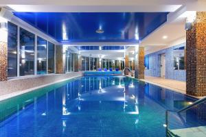 einen Pool in einem Hotel mit blauen Decken in der Unterkunft Spa Bagiński & Chabinka in Misdroy