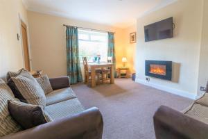 ein Wohnzimmer mit Couch und Kamin in der Unterkunft Host & Stay - Daisy Cottage in Bamburgh