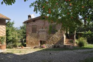 an old brick house with a tree in front of it at Agriturismo Colombino in Siena