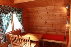 a room with a table and chairs in a log cabin at Lunde Camping in Aurland