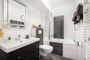 a bathroom with a toilet and a sink and a tub at Hotel Marktterrassen in Hennef