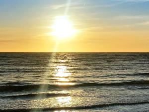 a sunset over the ocean with the sun in the sky at 5 person holiday home in Aakirkeby in Åkirkeby