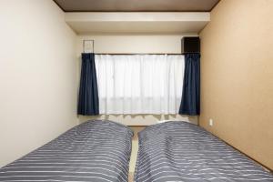 京町屋楓 Kyomachiya KAEDE في كيوتو: غرفة نوم بسريرين ونافذة