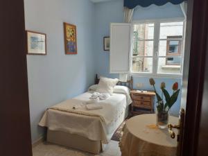 Dormitorio pequeño con cama y mesa en Pensión Pura, en Cuntis