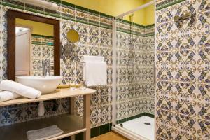 een badkamer met een wastafel en een douche bij Hôtel & Spa du Domaine des Thômeaux, The Originals Relais (Relais du Silence) in Mosnes
