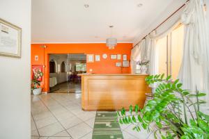 a courtroom with orange walls and a wooden bench at OYO Hotel Vila Rica, Ribeirão Preto in Ribeirão Preto