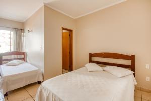 a bedroom with two beds and a window at OYO Hotel Vila Rica, Ribeirão Preto in Ribeirão Preto