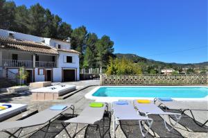 uma piscina com espreguiçadeiras e uma casa em Villa LAS ENCINAS-en el pueblo de Esporles- Mallorca em Esporles