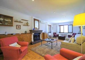 a living room with red chairs and a fireplace at Villa LAS ENCINAS-en el pueblo de Esporles- Mallorca in Esporles