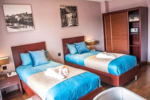 a bedroom with two beds with a dog laying on the bed at Havana Resort in Antananarivo