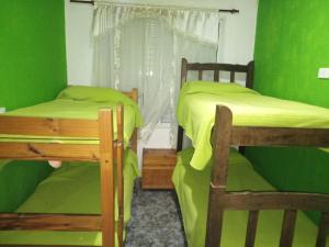 Cette chambre verte comprend 2 lits superposés et une fenêtre. dans l'établissement Casa Reinamora, à Villa Parque Siquiman