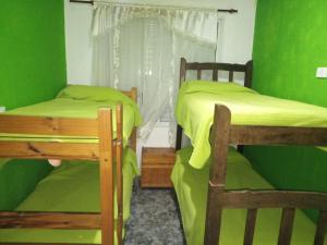 a green room with two bunk beds and a window at Casa Reinamora in Villa Parque Siquiman
