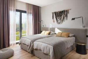 two beds in a bedroom with a window at Villa Ulmus in Karojba