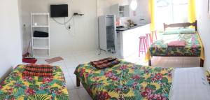 a living room with two beds and a kitchen at Flat Paraty Studio in Paraty +4 photos