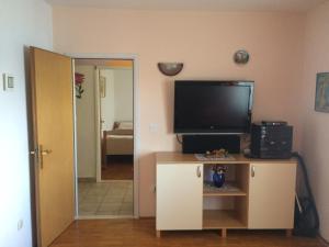 a living room with a flat screen tv on a cabinet at Apartments Tomović in Korčula