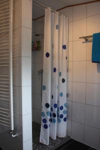 a bathroom with a shower curtain with blue dots at Haus Erika in Hemmoor