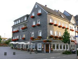 a large building with flowers on the side of it at Hotel-Restaurant Zum Schwanen in Wermelskirchen