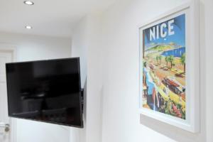 a picture hanging on a wall with a tv at NEWLY REFURBISHED 2 BEDROOM APARTMENT IN THE HEART OF GREENWICH in London