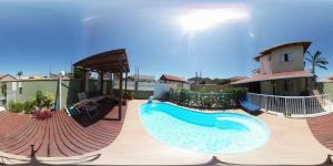een zwembad in een resort met een glijbaan en een huis bij Pousada Mar de Almirante in Penha
