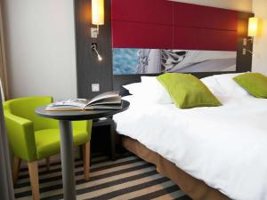 Un pat sau paturi într-o cameră la Mercure Honfleur