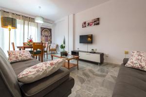 - un salon avec deux canapés et une télévision dans l'établissement Apartamentos Vado - Sendero del Veleta, à Cenes de la Vega