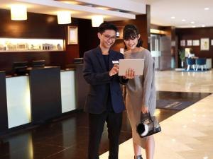 Un uomo e una donna che guardano un tablet di Mercure Convention Center Ancol a Giacarta