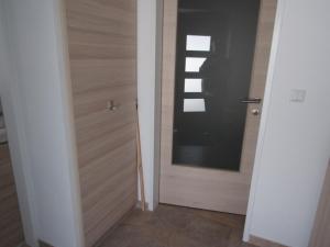 a hallway with a wooden door with a window at Peter Lamster Top2 in Frauenkirchen